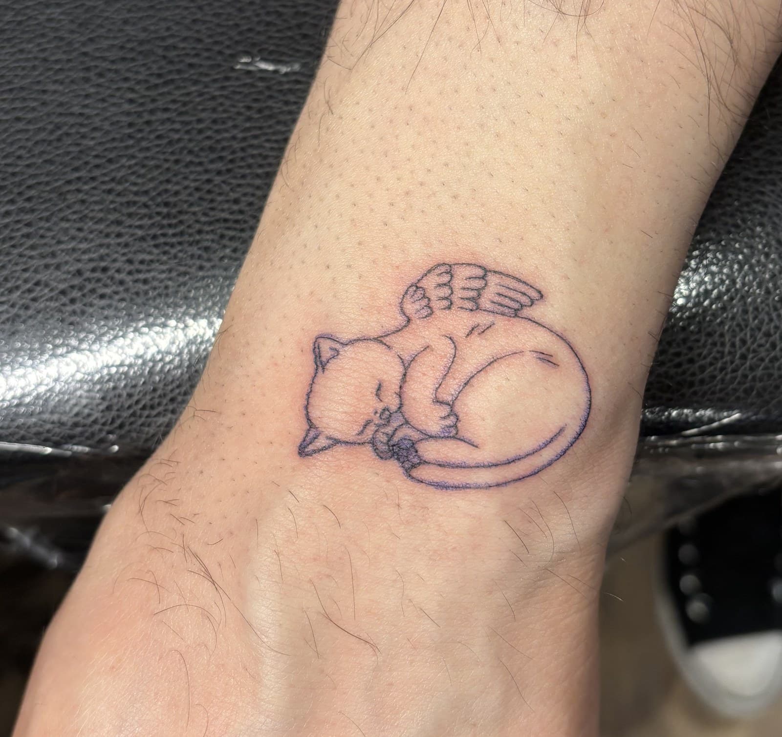 sleeping cat wrist tattoo by Taetyn Panagos